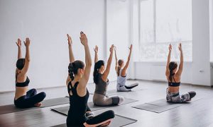 The group of women studies different types of yoga and their benefits.